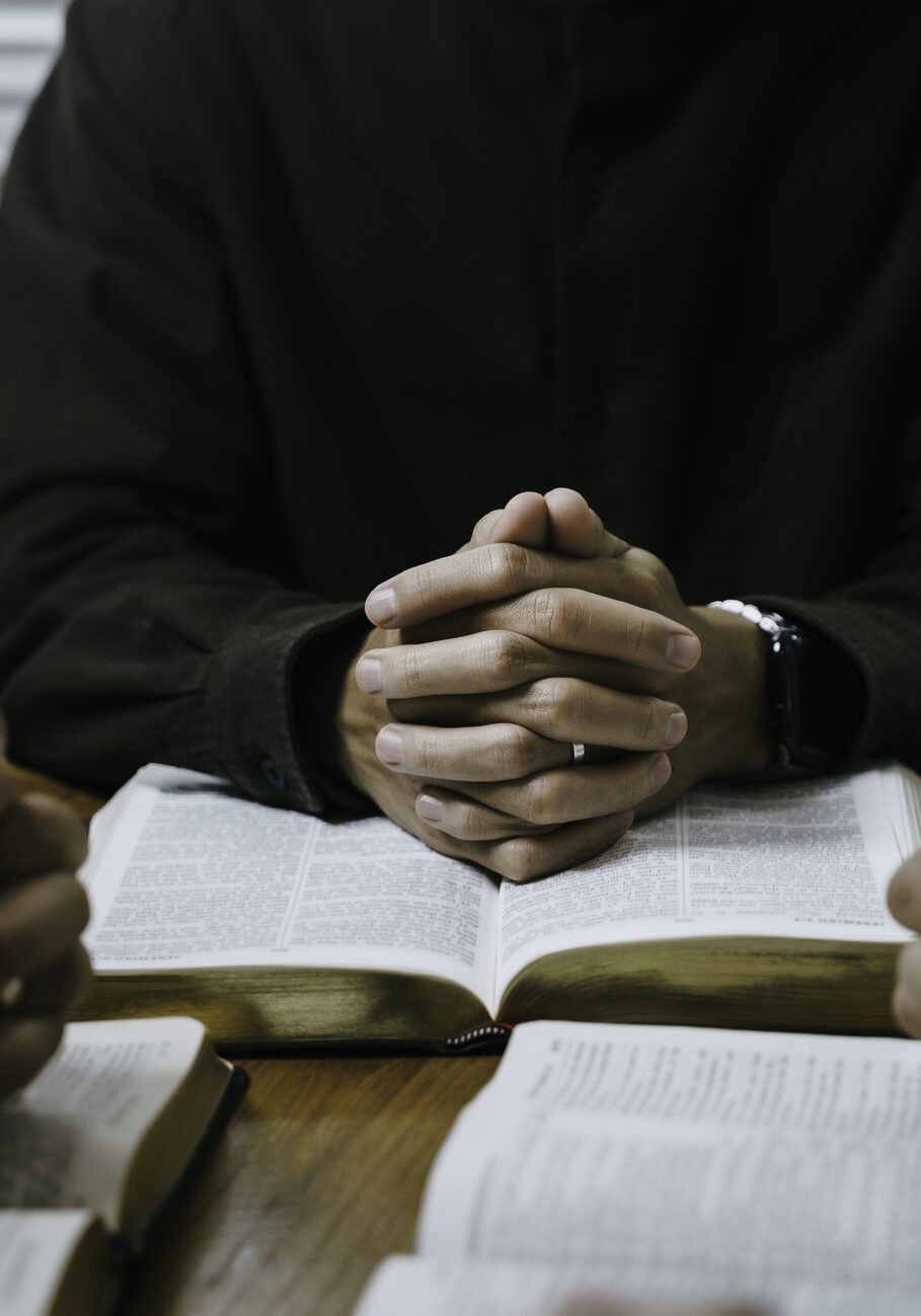Christian group of people holding hands pray and worship to believe and Bible on a wooden table prayer meeting concept. Christian Family prayer and worship. Church Community praying together